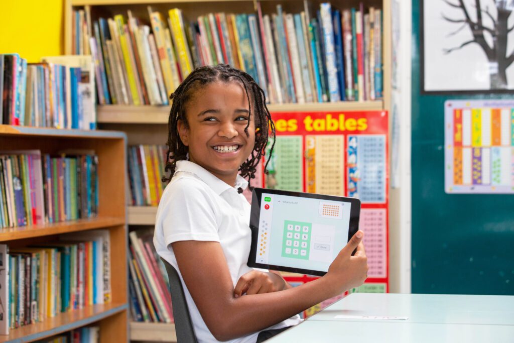 Child smiling proudly with DoodleMaths work