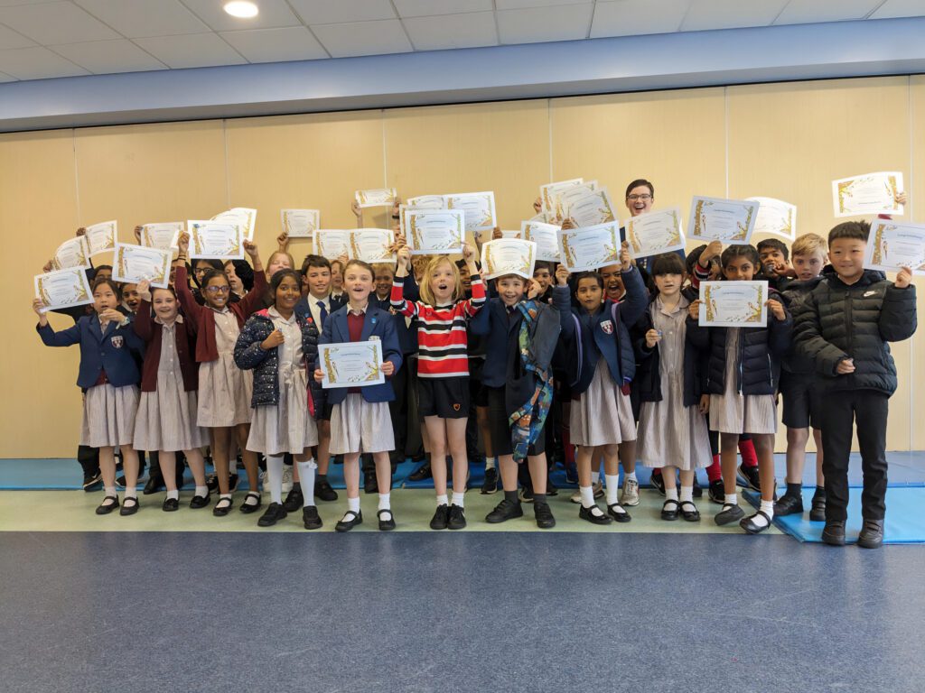 Pupils celebrate with certificates and badges.